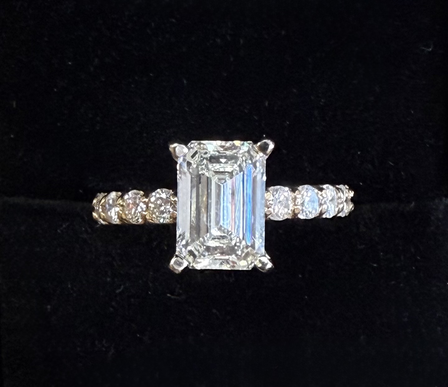 Emerald-cut diamond with accented diamond band